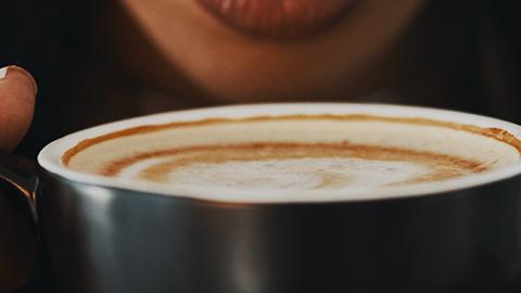 Woman smelling a cup of coffee