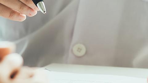 A healthcare provider wearing a stethoscope holding a pen and clipboard